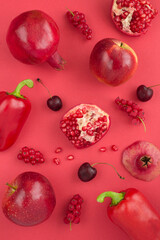 Top view of red vegetables and fruits on the red background. Location vertical.