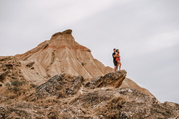 Couple on top of a rock on a desertic landscape