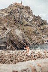 Young woman on the bridge of Gaztelugatxe Island