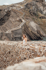 Young woman on the bridge of Gaztelugatxe Island