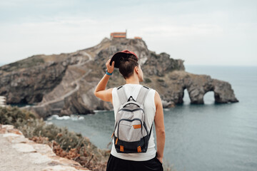 Young man with a hat in front of the Gaztelugatxe Island