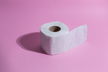 Toilete paper on a pink background. Minimal concept.