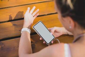 Mockup of a woman using her smartphone on a wood table
