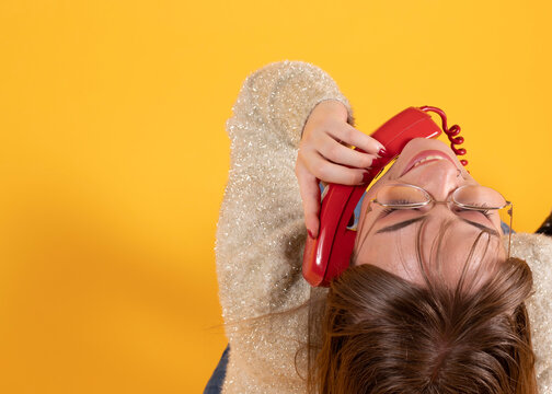 woman talking on old phone yellow background