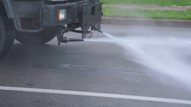 municipality big vehicle washing city asphalt road with water splashing cleaning concept