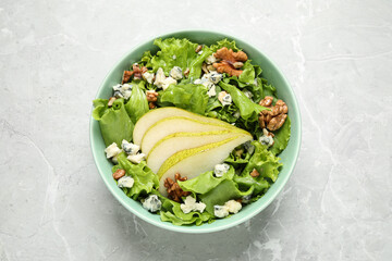 Tasty salad with pear slices on light grey marble table, top view