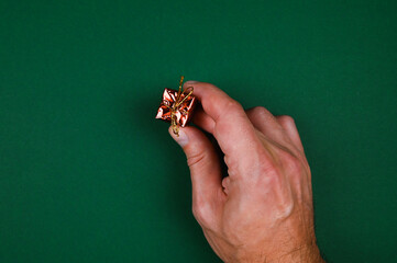 Hand holds a New Year's gift on a green background