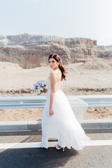 Fototapeta na wymiar Portrait of a beautiful bride with a bouquet in a white wedding dress