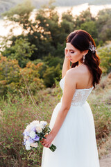 Fototapeta na wymiar Portrait of a beautiful bride with a bouquet in a white wedding dress