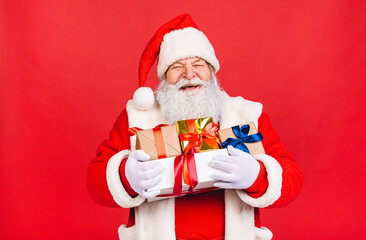 Photo of happy Santa Claus with present gift boxes lsolated over red background. Christmas and New Year concept.