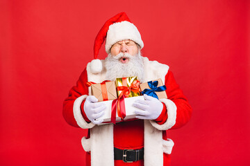 Photo of happy Santa Claus with present gift boxes lsolated over red background. Christmas and New Year concept.