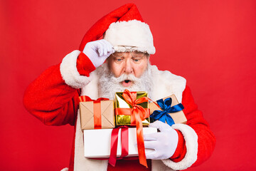 Photo of happy Santa Claus with present gift boxes lsolated over red background. Christmas and New Year concept.