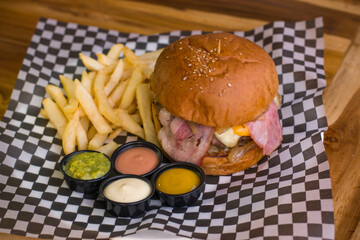 Hamburguesa de res con picanha, queso mozzarella y cheddar con tocineta,  papas a la francesa, salsas y guacamole