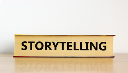 Book with text 'storytelling' on beautiful wooden table, white background. Business concept. Copy space.