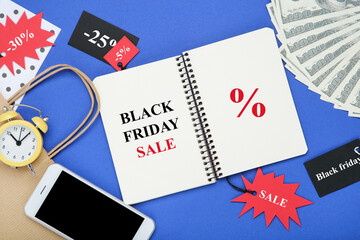 Text Black Friday Sale, smartphone, tags and dollar banknotes on blue background