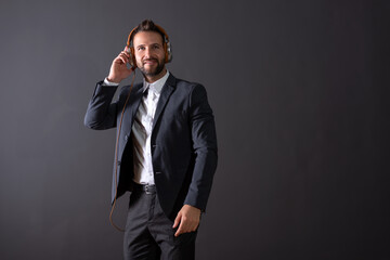 Naklejka premium A smiling young businessman listening to music