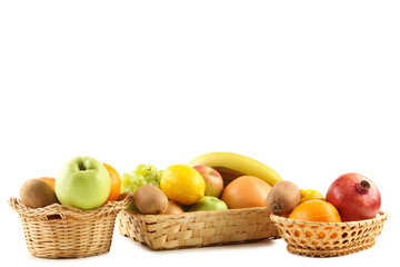 Different ripe fruits in baskets on white background