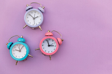 Simply minimal design three ringing twin bell classic alarm clock Isolated on purple violet background. Rest hours time of life good morning night wake up awake concept. Flat lay top view copy space.