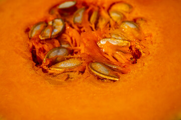 Macro pumpkin texture. Close up of organic, sliced pumpkin with seeds background