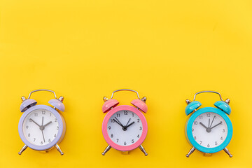 Simply minimal design three ringing twin bell classic alarm clock Isolated on yellow background....
