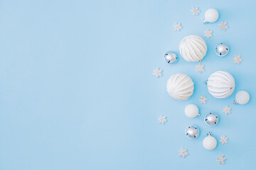 Flat lay border with christmas balls and snowflakes on a blue background