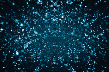 Snow, stars and sparkles on a blue textured background. Abstract new year background.