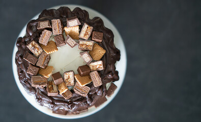 Top view of chocolate cake with cookies and pieces of chocolate 