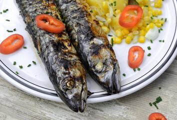 Mackerel fish dish with potatoes, red paprika, corn, onions and chives. Fatty, oily fish is an excellent and healthy source of DHA and EPA, which are two key types of omega-3 acid.