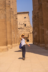 Fototapeta na wymiar A young tourist wearing a hat visiting the Egyptian Temple of Luxor. Egypt
