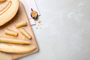 Sliced delicious ripe melon on grey marble table, flat lay. Space for text