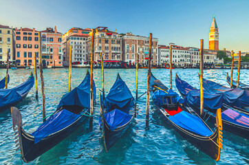 Fototapeta premium Watercolor drawing of Gondolas moored in water of Grand Canal waterway in Venice. Baroque style colorful buildings along Canal Grande and bell tower Campanile di San Marco. Typical Venice cityscape
