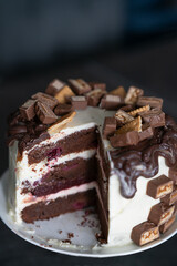Sliced chocolate cake with cookies and pieces of chocolate 