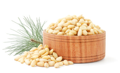 Pine nut in a wooden bowl and a pine branch on a white background. Isolated