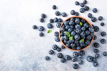 Blueberries in bowl on concrete background. Top view with copy space for text. Organic blueberries...