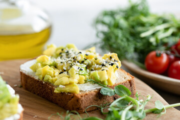 Bread toast with avocado, cream cheese and sesame seeds. Healthy breakfast or snack food
