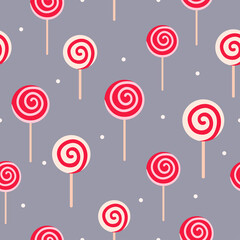 Light yellow and red lollipops with white dots on gray background. Seamless winter tasty pattern. Suitable for wrapping paper, wallpaper.