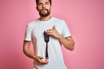 Man with spatula in hands kitchen accessories model emotions pink background cropped view Copy Space