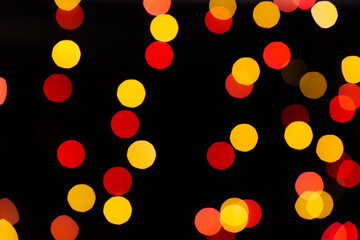 Red and orange bokeh from glowing garlands on a black background.