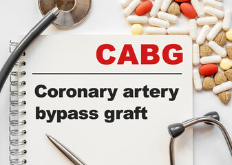 Page in notebook with CABG. Coronary artery bypass graft on white background with stethoscope and group of pill. Medical concept. Term and abbreviation
