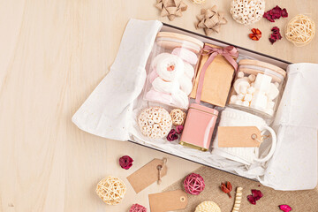 Fototapeta na wymiar Preparing care package, seasonal gift box with marshmallow, tea,coffee or cacao box and christmas ornament
