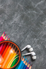 multicolored school supplies lie on black chalkboard, short focus, partial blur