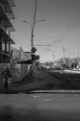 Fototapeta na wymiar Tiraspol, Moldova - January 19, 2019: A woman and a man walk along an unfinished building. black and white street photo