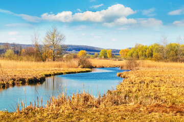 Spring landscape with river and picturesque blue sky with white clouds