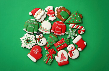 Different Christmas gingerbread cookies on green background, flat lay