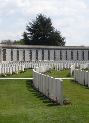 Fototapeta na wymiar British and Commonwealth WW1 graves, Tyne Cot Cemetery, Belgium, with memorial wall to the missing in background