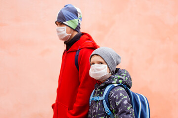 schoolchildren in protective masks in the street