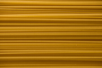Yellow raw spaghetti background texture close up.