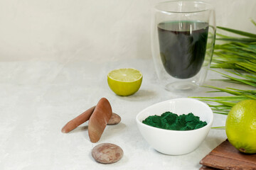 Spirulina drink with lime and spirulina algae powder on white plate. Superfood detox drink. Natural antioxidant. Anti-aging effect. Green diet. Copy space.
