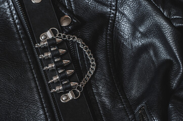 Black leather bracelet with bullets on a leather jacket.