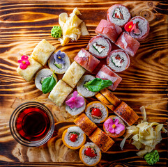 set of sushi roll with salmon, avocado, cream cheese, cucumber, rice, caviar, eel, tuna on wooden table